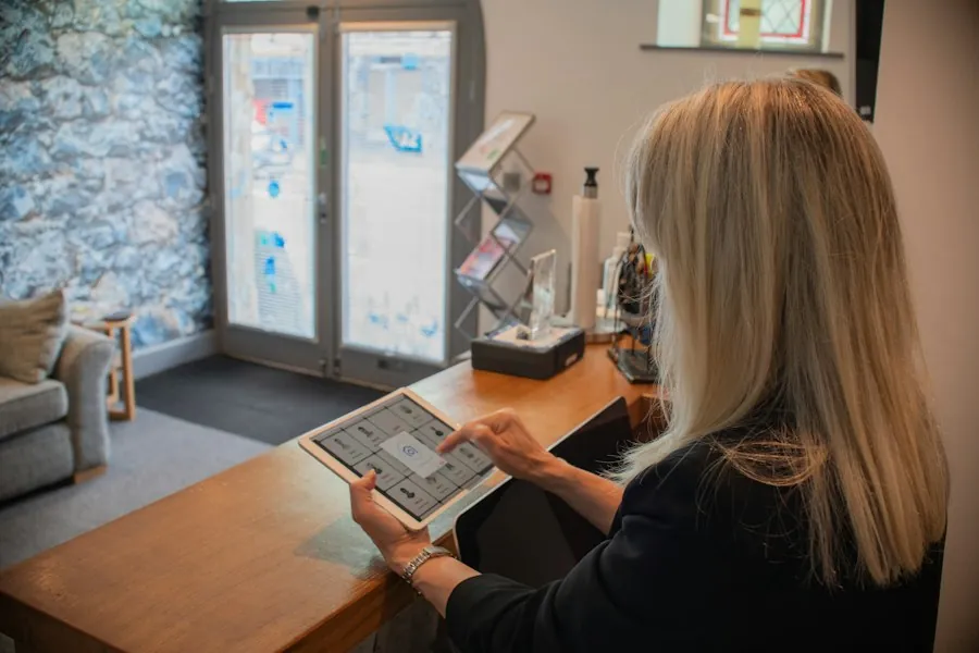 A receptionist checking bookings on a tablet at the front desk