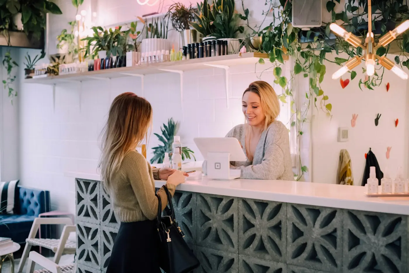 A receptionist checking bookings on a tablet at the front desk